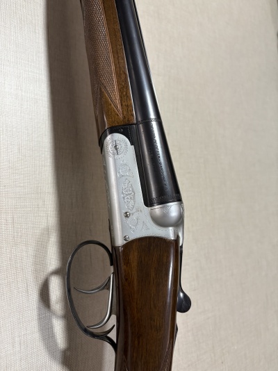 Espingarda de canos duplos com madeira e metal escuro, com gravações e texto PIETRO BERETTA GARDONE V.T. MADE IN ITALY.
