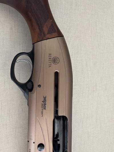Espingarda Beretta com madeira castanha e corpo bege com texto preto XPLOR ACTION