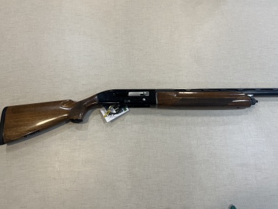 Espingarda com madeira castanho escuro e metal preto, sobre tecido cinza claro