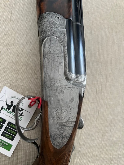 Espingarda com gravação detalhada em metal e madeira escura sobre fundo de tecido bege