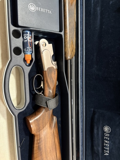 Espingarda Beretta em estojo azul escuro com frasco de óleo