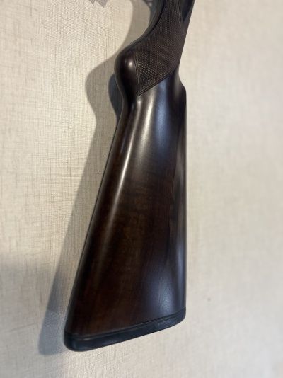 Coronha de espingarda em madeira escura com detalhe texturizado