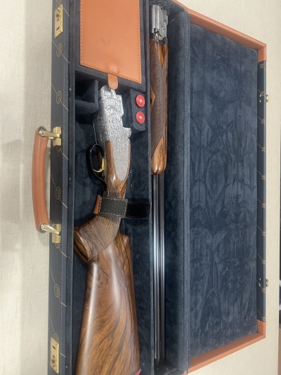 Espingarda desmontada em caixa de transporte com interior azul e couro castanho