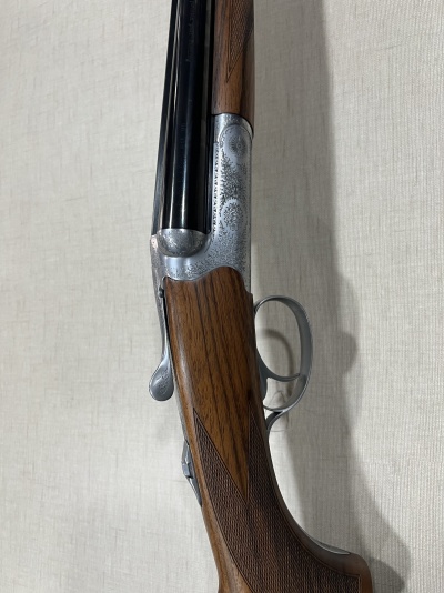 Espingarda de canos paralelos com coronha em madeira e metal prateado