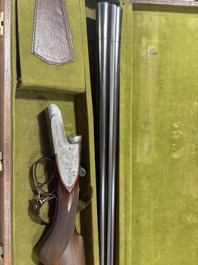 Espingarda de caça de canos duplos em estojo verde de veludo