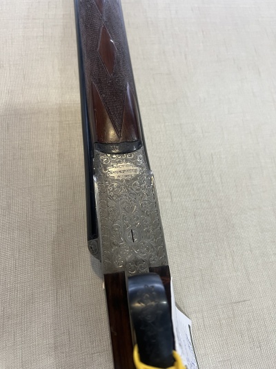 Parte próxima da coronha de arma de fogo em madeira e metal decorado