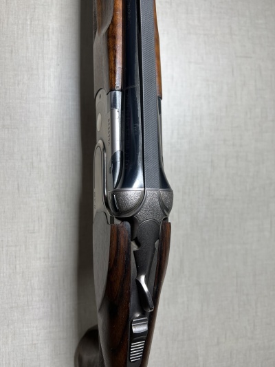 Espingarda de canos paralelos com coronha de madeira e metal prateado