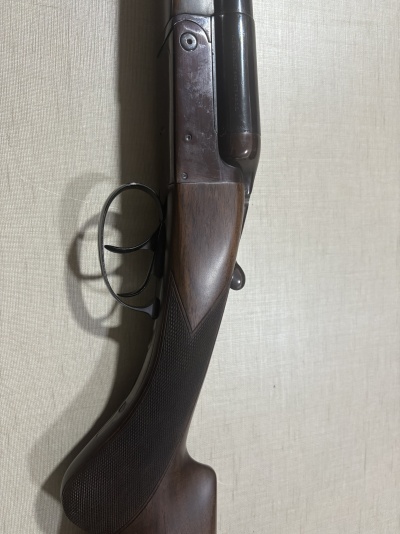 Espingarda de canos duplos com coronha em madeira escura e gatilhos metálicos