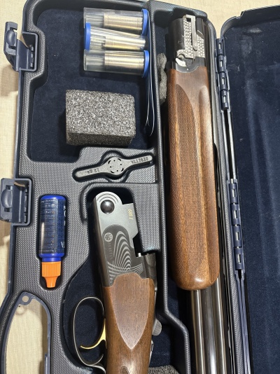 Caixa aberta com espingarda Beretta desmontada e acessórios