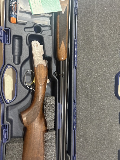 Espingarda Beretta em estojo azul com acessórios de limpeza e manuais