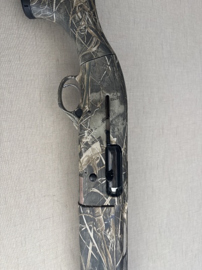 Espingarda camuflada com texto BIALTRA MAX contra fundo cinza