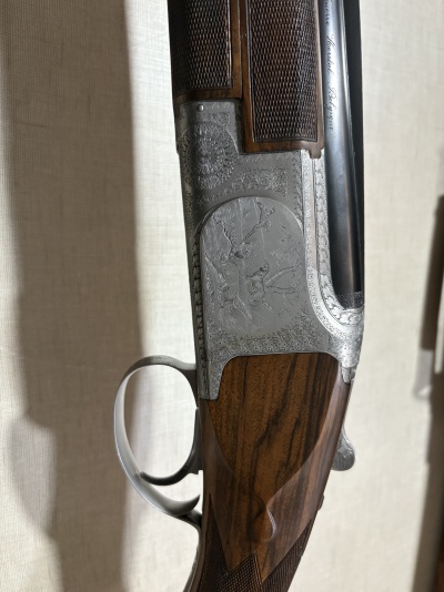 Espingarda de caça com gravações em metal prateado e madeira escura