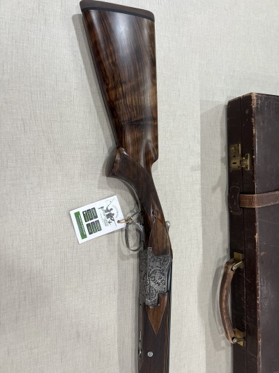Espingarda de caça com coronha em madeira escura e estojo em couro castanho