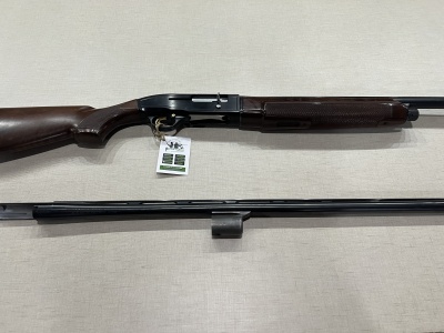 Espingarda de pressão em madeira escura e metal preto sobre fundo claro