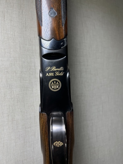 Arma de caça Beretta ASE Gold com acabamento em madeira e metal preto com detalhes dourados