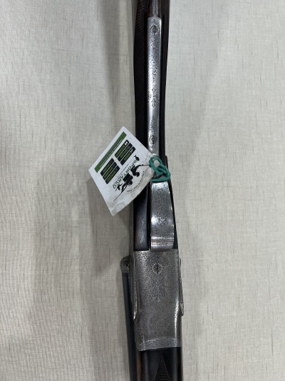 Espingarda de caça com detalhes metálicos gravados pendurada com cartão branco