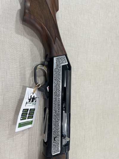 Espingarda com gravação ornamental prateada e coronha em madeira castanha