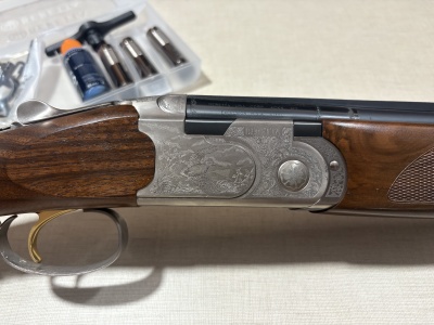 Espingarda Beretta em madeira castanha com metal gravado prateado e preto