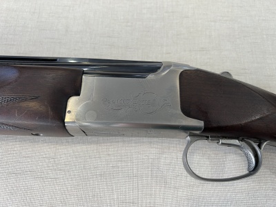 Espingarda semiautomática com armação prateada e madeira castanha