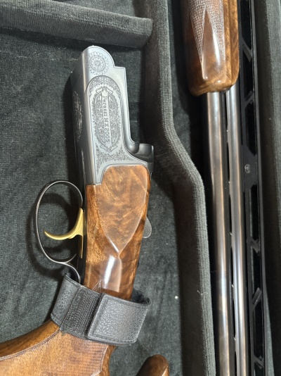 Espingarda Perazzi MX2005 com acabamento em madeira e detalhes em metal dentro de estojo
