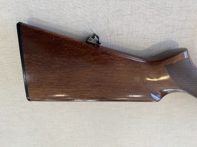 Coronha de arma de fogo em madeira castanha com acessório metálico