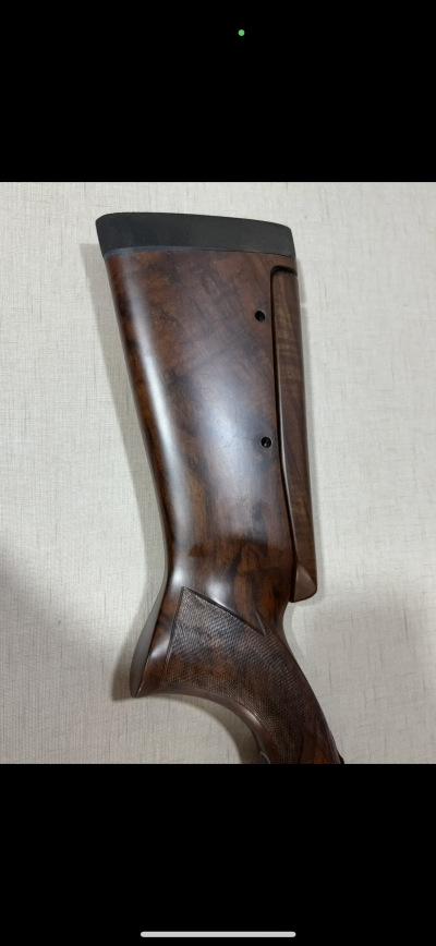 Coronha de arma em madeira castanha com ponteira preta e detalhes em textura