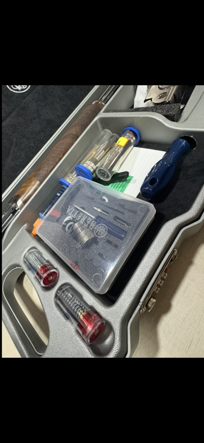 Estojo cinzento aberto com peças e ferramentas para arma de fogo com indicação BERETTA.