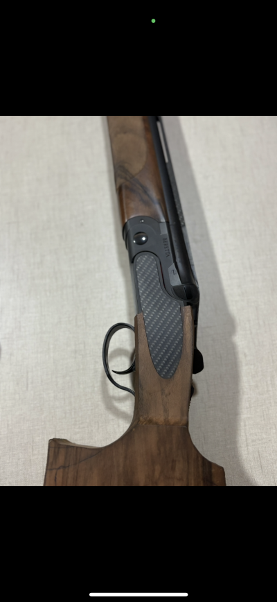 Espingarda coronha de madeira castanha e empunhadura preta texturizada com inscrição BERETTA