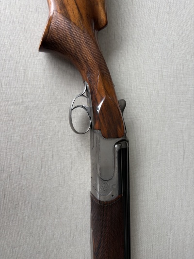 Rifle de caça com coronha em madeira castanha e armação metálica prateada
