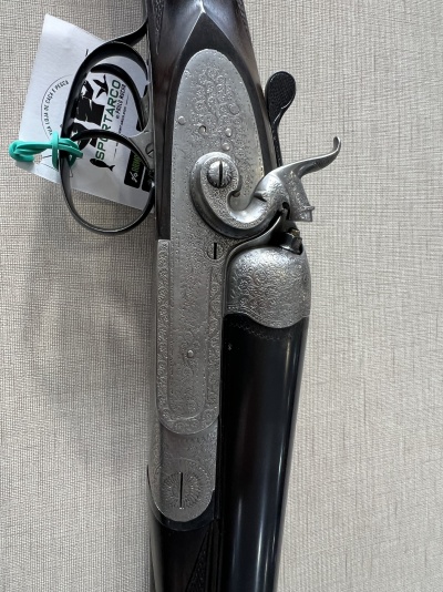 Espingarda de cano duplo com acabamento metálico gravado e madeira escura polida com etiqueta