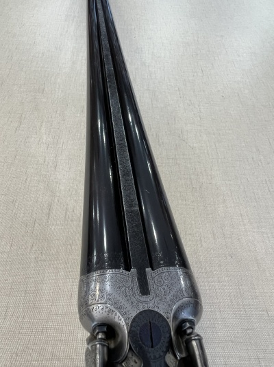 Canos duplex de arma de fogo em metal prateado gravado com canos pretos lushtrosos sobre tecido bege