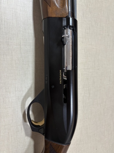 Espingarda Beretta Montefeltro com coronha de madeira e corpo metálico preto e prateado