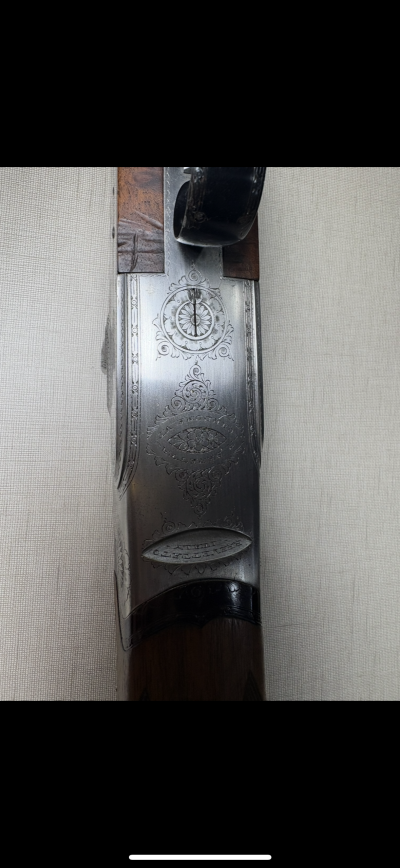 Parte superior de espingarda com metal gravado em prateado e madeira castanha