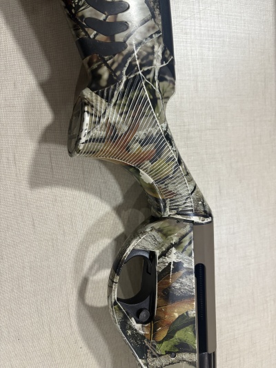 Coronha e empunhadura de arma com padrão camuflado verde, castanho e bege