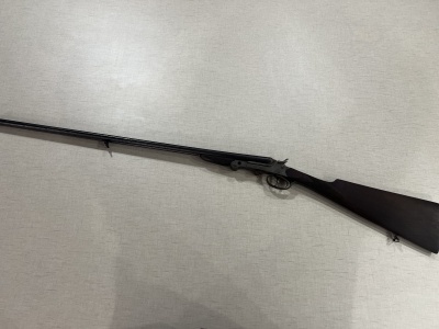 Espingarda de cano duplo com coronha em madeira escura e canos metálicos negros