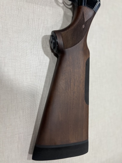 Coronha de madeira escura com textura quadriculada e proteção preta