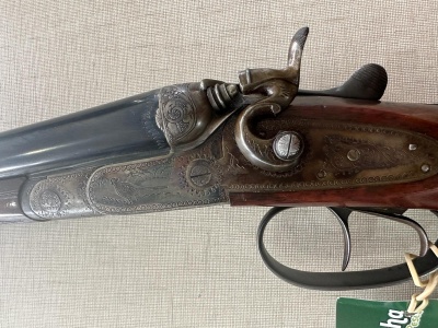 Espingarda de canos duplos com gravações e empunhadura de madeira