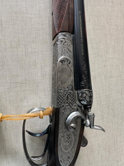 Espingarda de caça com gravações ornamentais e cabo de madeira castanha