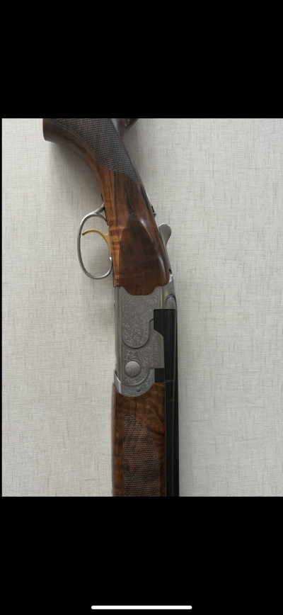 Espingarda de caça com madeira escura e corpo metálico decorado