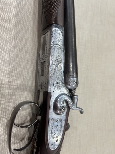 Espingarda com coronha em madeira escura e detalhes metálicos gravados