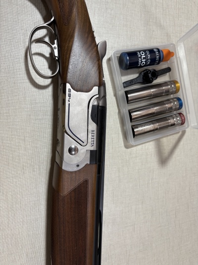 Espingarda Beretta com estojo e acessórios para manutenção.