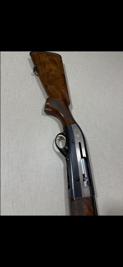 Espingarda com coronha de madeira castanha polida e corpo metálico preto