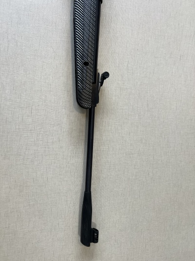 Carabina de ar comprimido preta com textura padrão carbono pendurada na parede