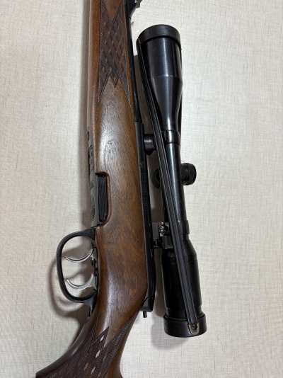 Rifle de madeira escura com luneta preta montada