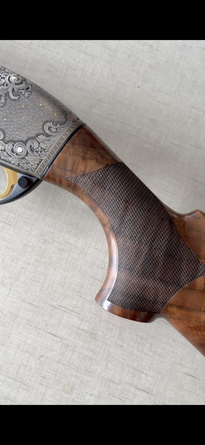 Coronha de espingarda em madeira com textura quadriculada e ornamentos metálicos gravados