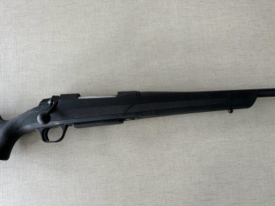 Rifle preto com coronha ergonómica sobre fundo claro