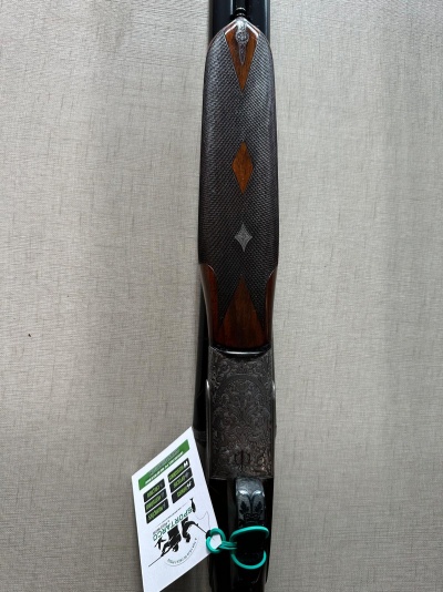 Espingarda com empunhadura em madeira entalhada e corpo metálico decorado