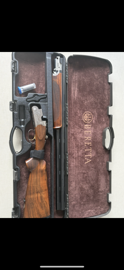 Espingarda Beretta desmontada num estojo preto aberto com veludo castanho interior e texto BERETTA