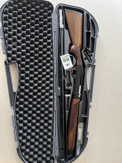 Espingarda desmontada em estojo rígido cinzento com espuma preta ondulada na tampa