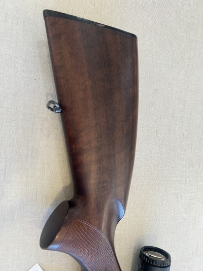 Coroanha de arma de caça em madeira castanha sobre tecido bege